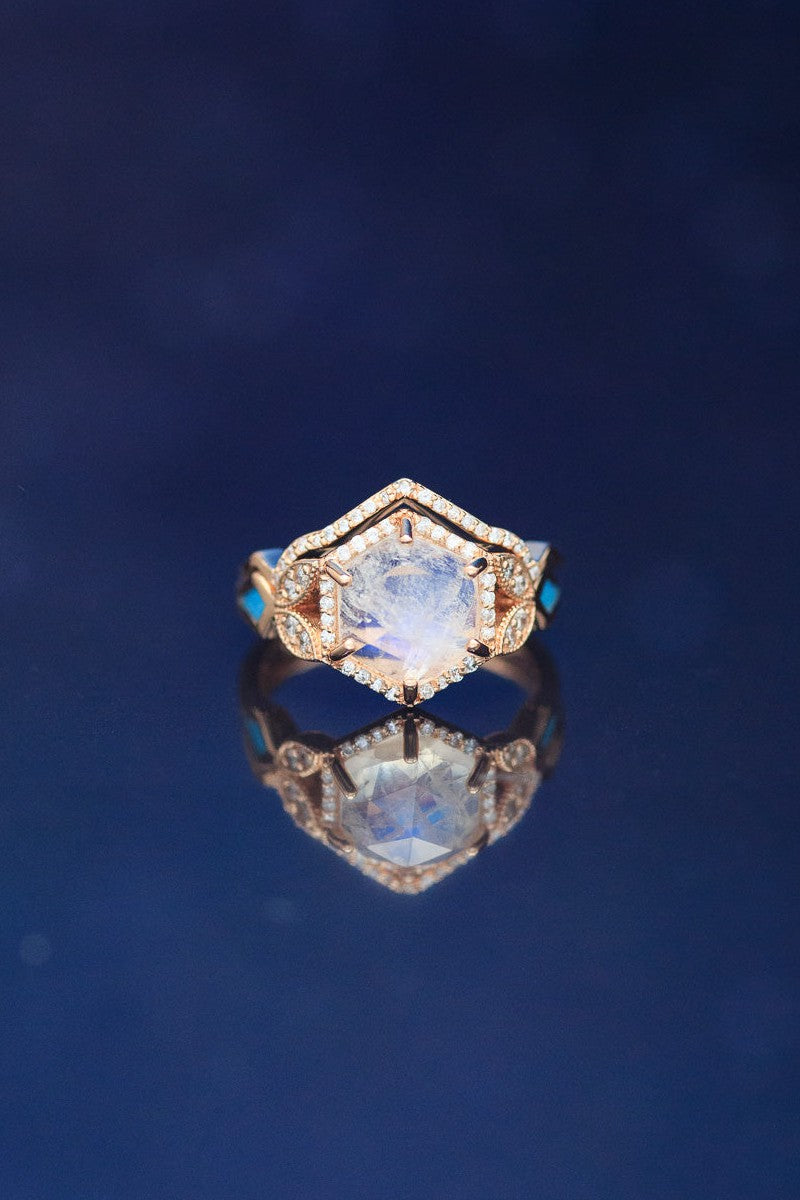 Shown here is The "Lucy in the Sky", a halo-style hexagon faceted moonstone women's engagement ring with delicate and ornate details and is available with many center stone options