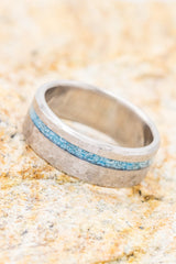 Shown her is Ring Style: "Vertigo", a custom, handcrafted men's wedding ring featuring a turquoise inlay, shown here on a hammered titanium band. Additional inlay options are available upon request.