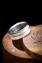 Shown here is A custom, handcrafted men's wedding ring featuring naturally shed elk antler, shown here set on hand-turned titanium, and is divided by a 14K yellow gold inlay. Additional inlay options are available upon request.