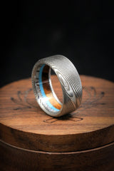 Shown here is "Banner", a custom, handcrafted men's wedding ring featuring turquoise,  ironwood, and naturally shed antler lining, shown here on a Damascus Steel band. Additional inlay options are available upon request.-Damascus Steel Wedding Band With Antler, Wood & Turquoise Lining - Staghead Designs