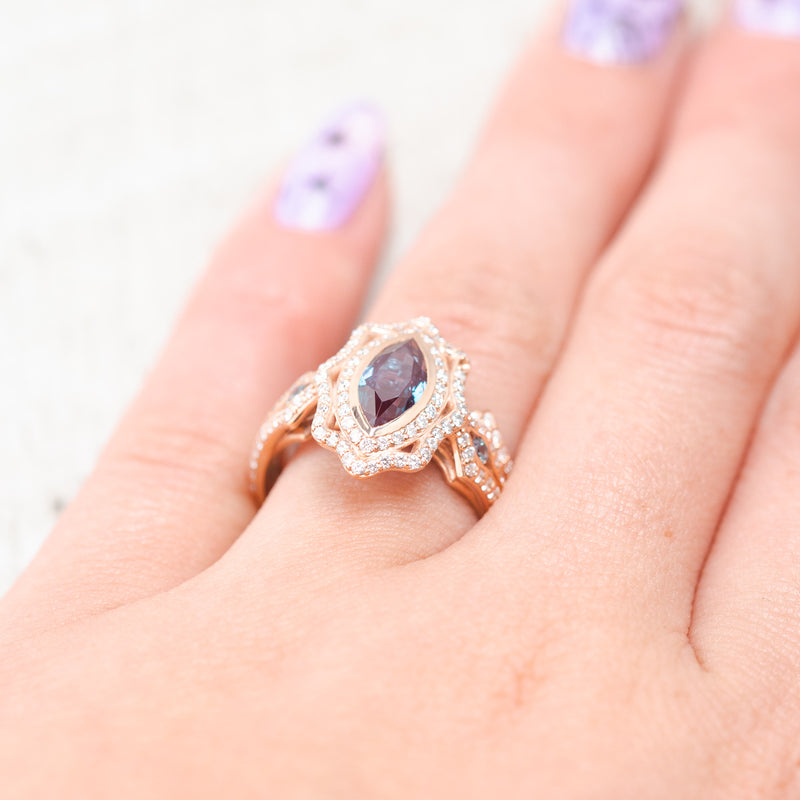 Shown here, Adele,  a marquise lab-created alexandrite women's engagement ring with alexandrite accents, diamond halo and diamond tracer, on hand. Many other center and side stone options are available upon request.