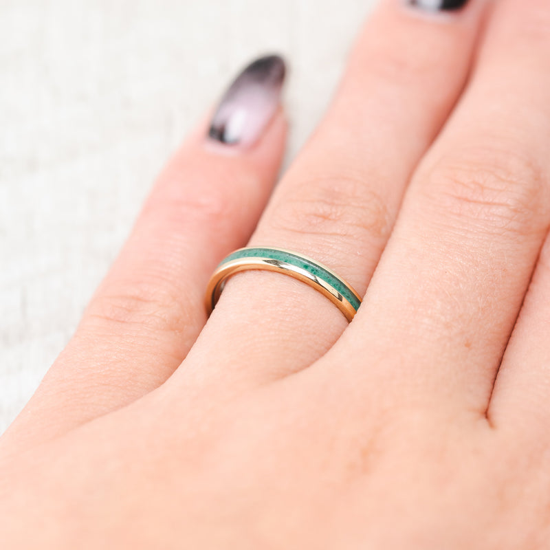 Shown here, Eterna,  a custom, handcrafted women's stacking band featuring a malachite inlay, shown here on a yellow gold band, on hand. Additional inlay options are available upon request.