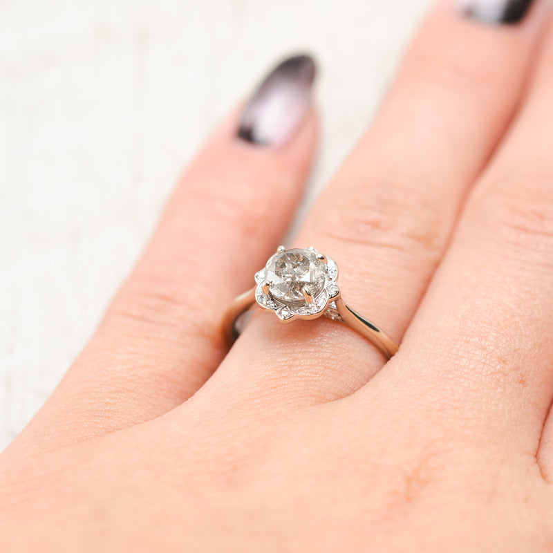 Shown here, Jane, a halo-style salt and pepper diamond women's engagement ring with a floral diamond halo and diamond tracer, on hand. Many other center stone options are available upon request.