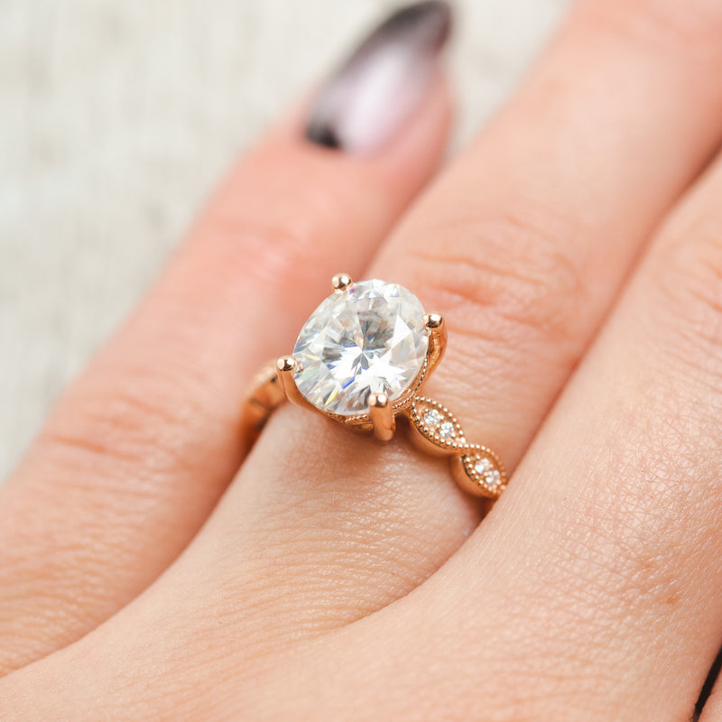Shown here, Nour, a scallop-style moissanite women's engagement ring with diamond accents, on hand. Many other center stone options are available upon request. 