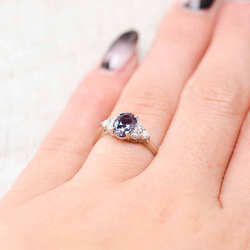 Shown here, The Rhea, a lab-created alexandrite women's engagement ring with diamond accents, on hand. Many other center stone options are available upon request.