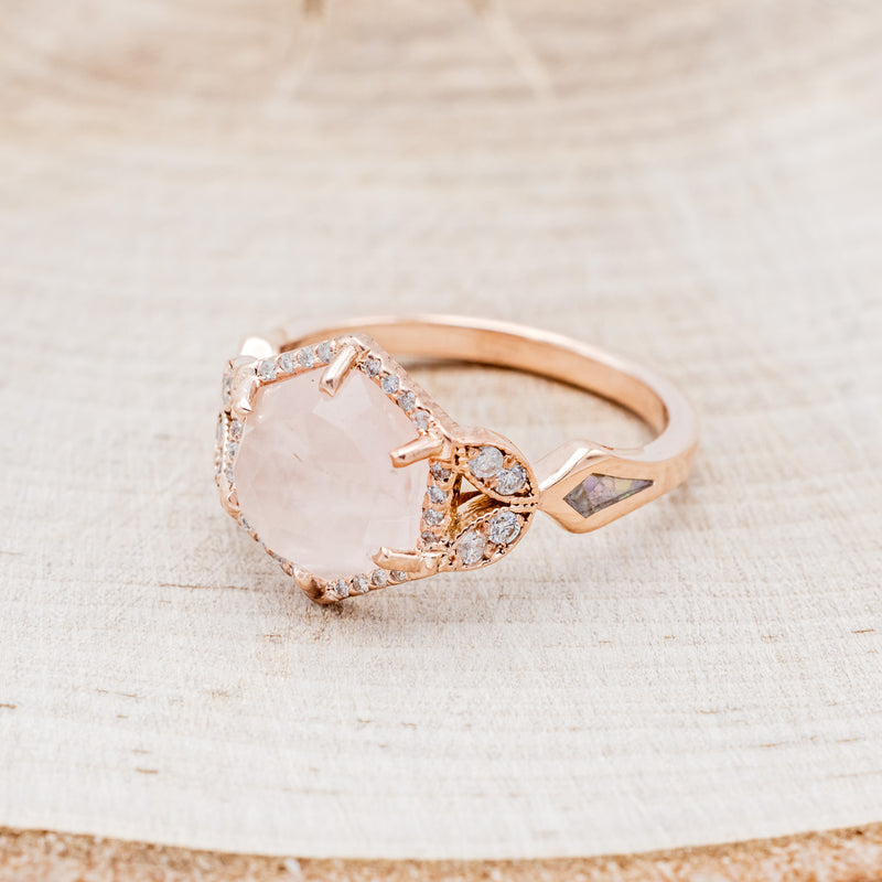 Shown here is "Lucy in the Sky" is a halo-style hexagon faceted rose quartz women's engagement ring with diamond accents, mother of pearl inlays, facing left. Many other center stone options are available upon request.