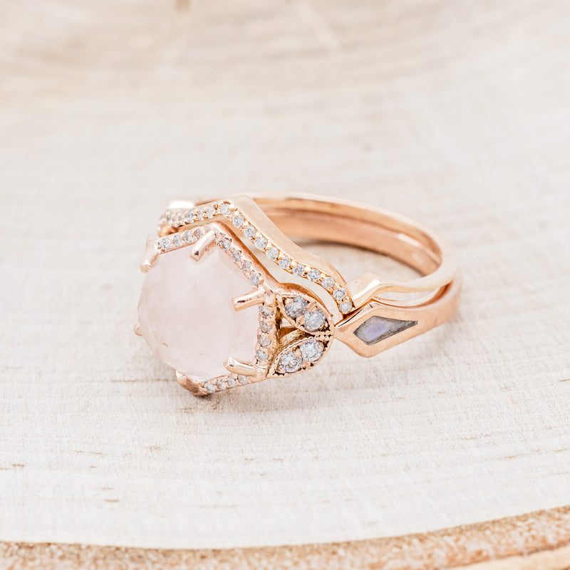 Shown here is "Lucy in the Sky" is a halo-style hexagon faceted rose quartz women's engagement ring with diamond accents, mother of pearl inlays, and a diamond tracer, facing left. Many other center stone options are available upon request.