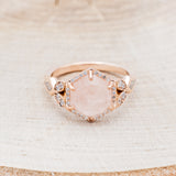 Shown here is "Lucy in the Sky" is a halo-style hexagon faceted rose quartz women's engagement ring with diamond accents, mother of pearl inlays, facing front. Many other center stone options are available upon request.
