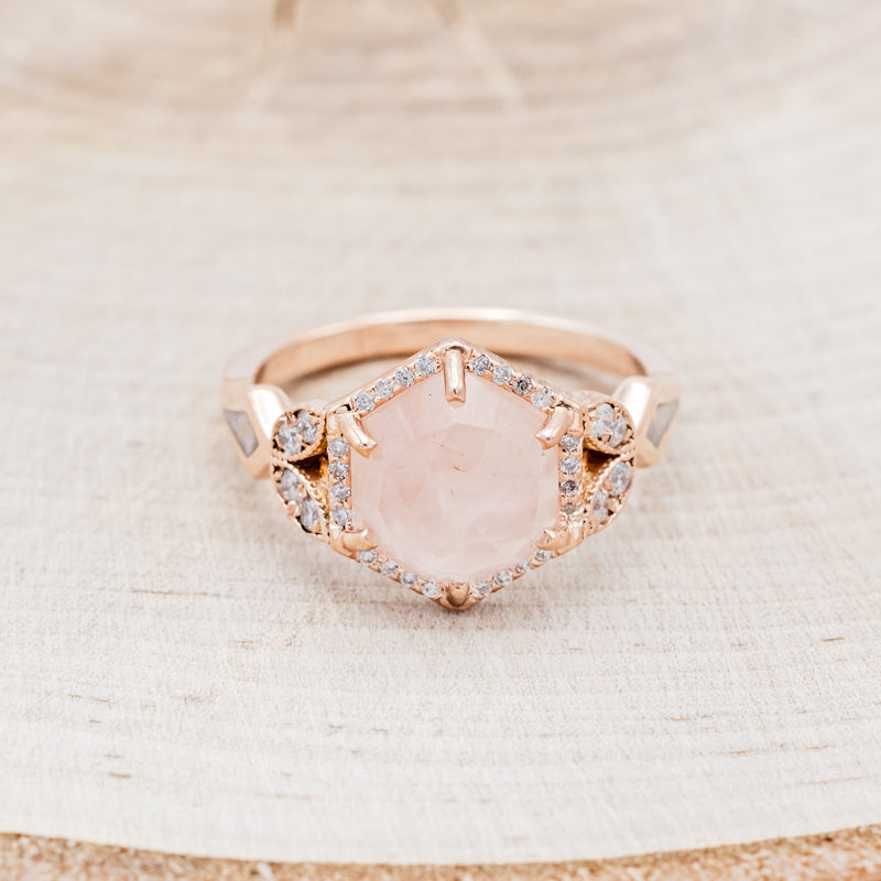 Shown here is "Lucy in the Sky" is a halo-style hexagon faceted rose quartz women's engagement ring with diamond accents, mother of pearl inlays, facing front. Many other center stone options are available upon request.