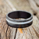 Shown here is "Vertigo", a custom, handcrafted men's wedding ring featuring a mother of pearl inlay, laying flat. Additional inlay options are available upon request.