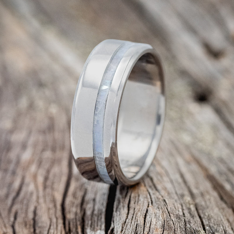 Shown here is "Vertigo", a handcrafted men's wedding ring featuring a mother of pearl inlay, upright facing left. 