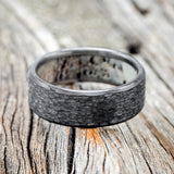 Shown here is a handcrafted men's wedding ring featuring a hammered finish and antler lining on any of our available base material options, laying flat. Additional inlay options are available upon request.