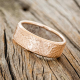 Shown here is a handcrafted men's wedding ring featuring a hammered finish and antler lining on any of our available base material options, tilted left. Additional inlay options are available upon request.