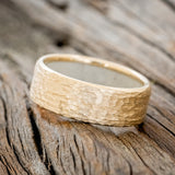 Shown here is a handcrafted men's wedding ring featuring a hammered finish and antler lining on any of our available base material options, tilted left. Additional inlay options are available upon request.
