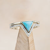 Shown here is "Jenny From The Block", a dainty-style triangle turquoise women's engagement ring with a diamond v-shaped tracer, on stand front facing. Many other center stone options are available upon request.