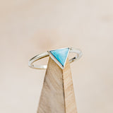 Shown here is "Jenny From The Block", a dainty-style triangle turquoise women's engagement ring, on stand front facing. Many other center stone options are available upon request.
