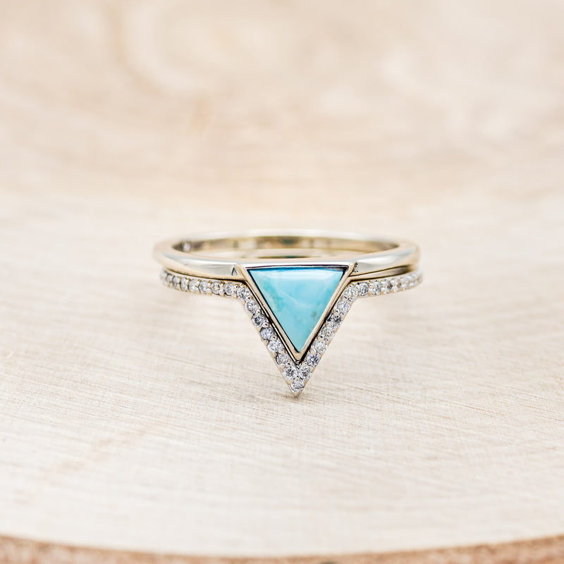 Shown here is "Jenny From The Block", a dainty-style triangle turquoise women's engagement ring with a diamond v-shaped tracer, front facing. Many other center stone options are available upon request.