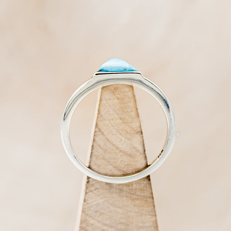 Shown here is "Jenny From The Block", a solitaire-style triangle turquoise women's engagement ring, side view on stand. Many other center stone options are available upon request.