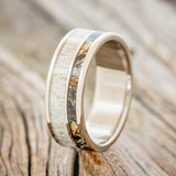 Shown here is "Raptor", a custom, handcrafted men's wedding ring featuring a camo and antler inlay, upright facing left. Additional inlay options are available upon request.