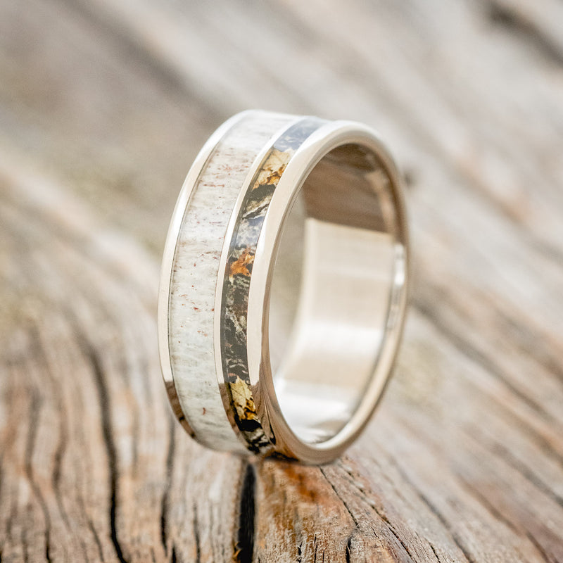 Shown here is "Raptor", a handcrafted men's wedding ring featuring a camo and elk antler inlay, upright facing left. 