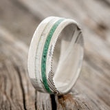 Shown here is "Cosmo", a custom, handcrafted men's wedding ring featuring 2 offset channels with elk antler and hand-crushed malachite inlays, upright facing left.