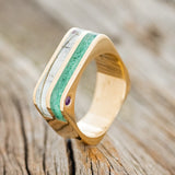 Shown here is "Vega", a custom, handcrafted men's wedding band featuring antler and malachite inlays with two offset amethyst, upright facing left. Additional inlay options are available upon request.