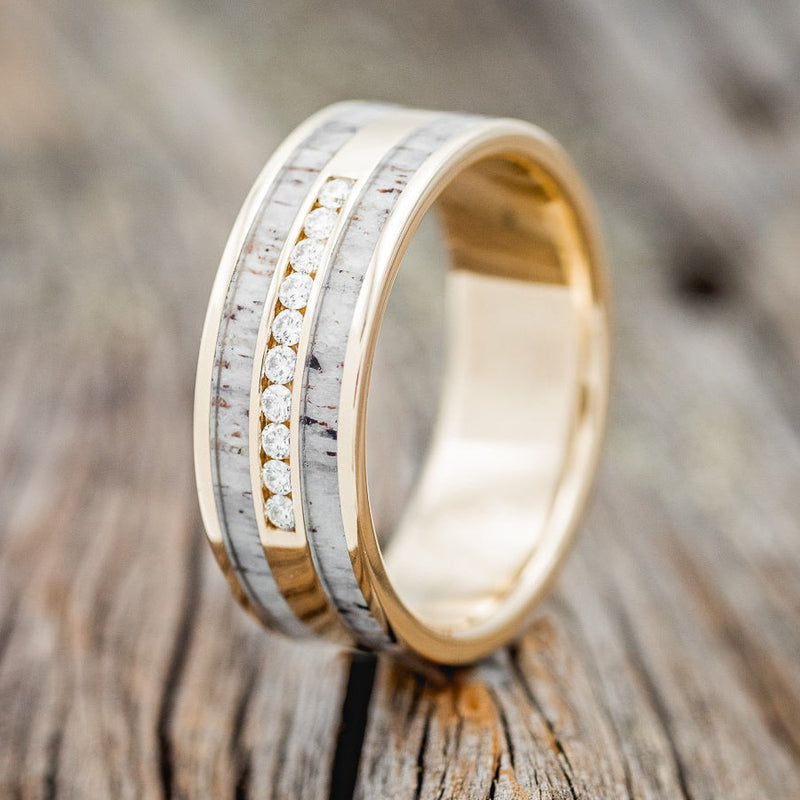 Shown here is "Ryder", a custom, handcrafted men's wedding ring featuring elk antler inlays, upright facing left. The middle section also has a section of 10 diamonds. Additional inlay options are available upon request.
