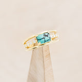 Shown here is "Dolly", a turquoise women's engagement ring with diamond accents, on stand facing slightly right. Many other center stone options are available upon request.