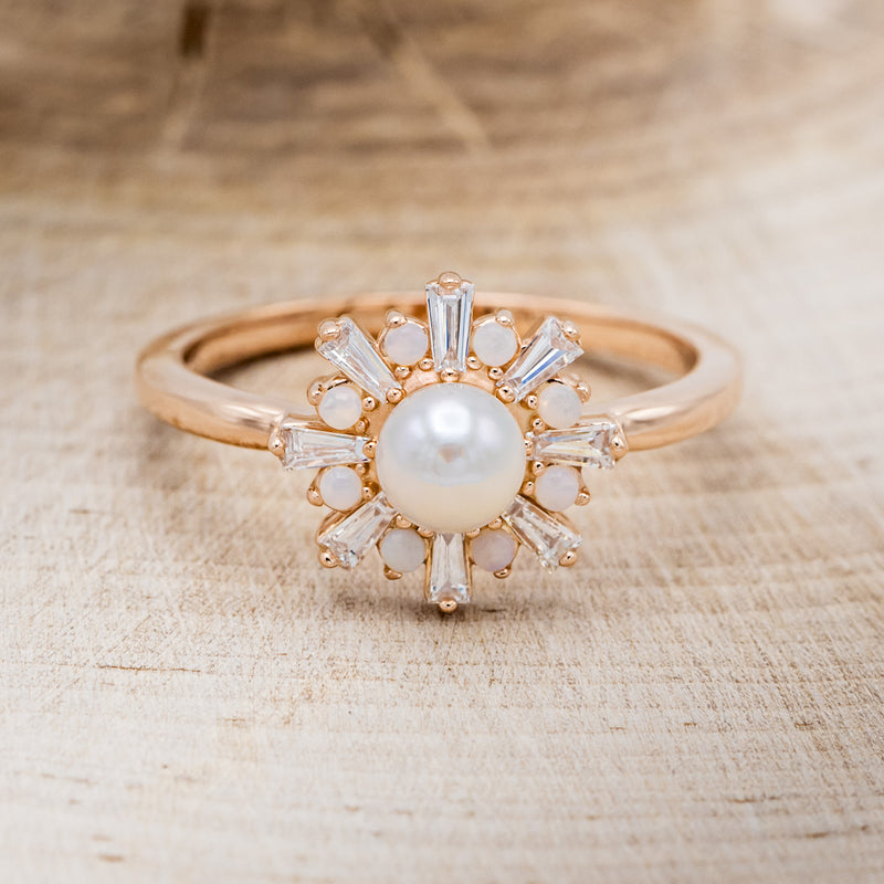 Shown here is "Dorothea", a white Akoya pearl women's engagement ring with opal and diamond accents, front facing. Many other center stone options are available upon request.