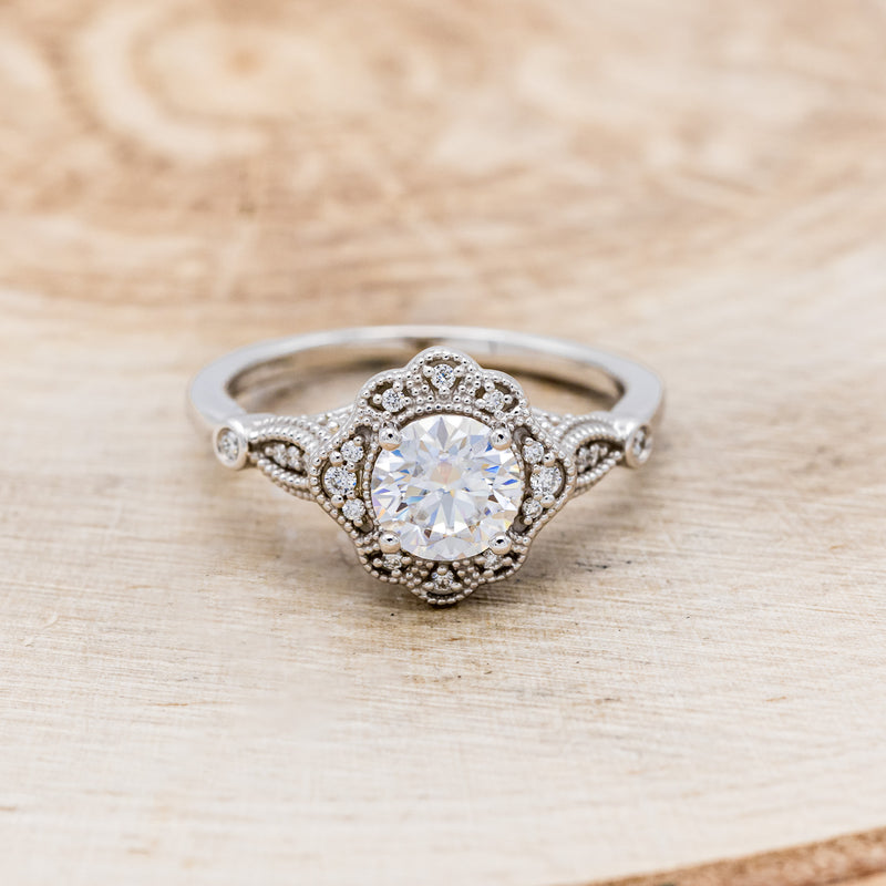 Shown here is "Eileen", a vintage-style moissanite women's engagement ring with diamond accents, front facing. Many other center stone options are available upon request.