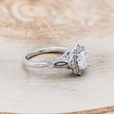 Shown here is "Eileen", a vintage-style moissanite women's engagement ring with diamond accents, facing right. Many other center stone options are available upon request.