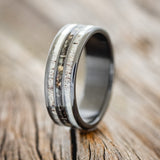 Shown here is "Rio", a custom, handcrafted men's wedding ring featuring 3 channels with antler and camo inlays, upright facing left. Additional inlay options are available upon request.