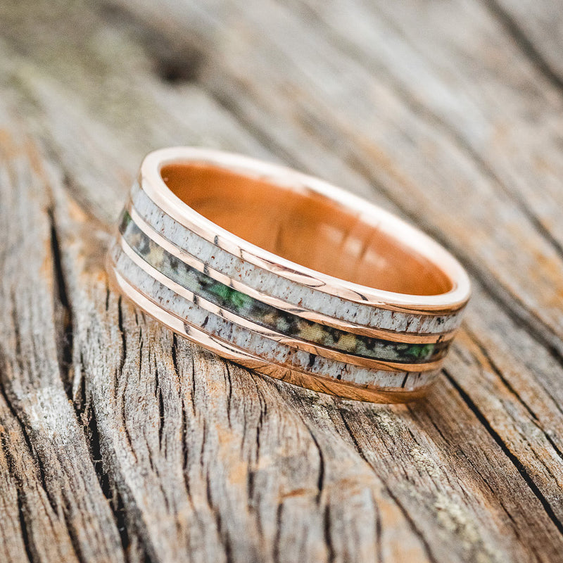 Shown here is "Rio", a custom, handcrafted men's wedding ring featuring 3 channels with antler and camo inlays, tilted left. Additional inlay options are available upon request.