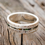 Shown here is "Rio", a custom, handcrafted men's wedding ring featuring 3 channels with antler and camo inlays, laying flat. Additional inlay options are available upon request.