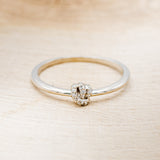 Shown here is a dainty-style knot women's stacking band with diamond accents, front facing.
