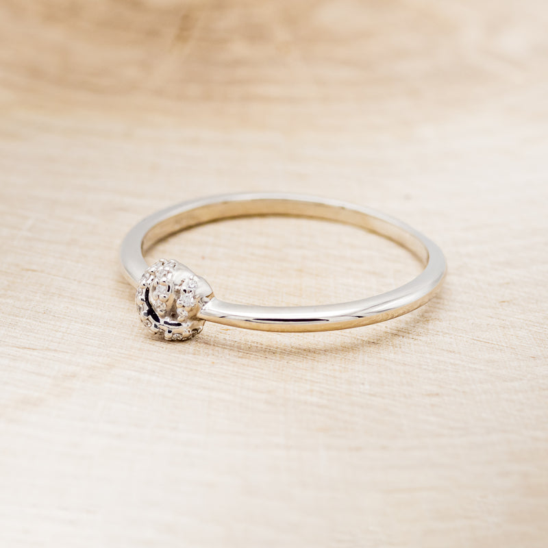 Shown here is a dainty-style knot women's stacking band with diamond accents, facing left.