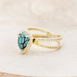 Shown here is "Nala", a split shank-style turquoise women's engagement ring with a diamond halo and diamond accents, facing left. Many other center stone options are available upon request.
