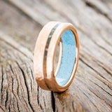 Shown here is "Vertigo", a custom, handcrafted men's wedding ring featuring an offset copper patina inlay and a turquoise lining on a hammered 14K gold band, upright facing left. Additional inlay options are available upon request.