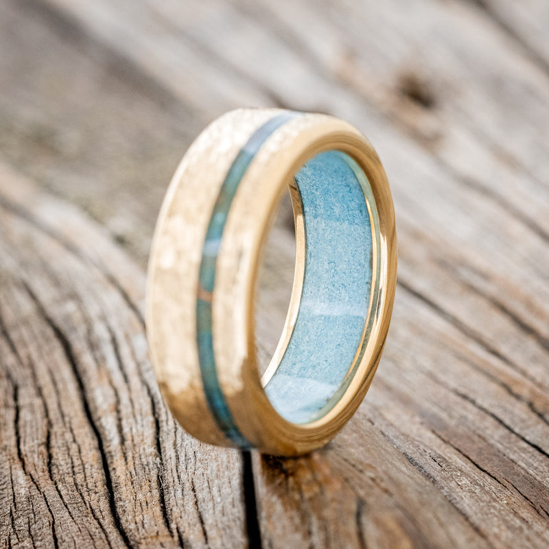  Shown here is "Vertigo", a custom, handcrafted men's wedding ring featuring an offset copper patina inlay and a turquoise lining on a hammered 14K gold band, upright facing left. Additional inlay options are available upon request.