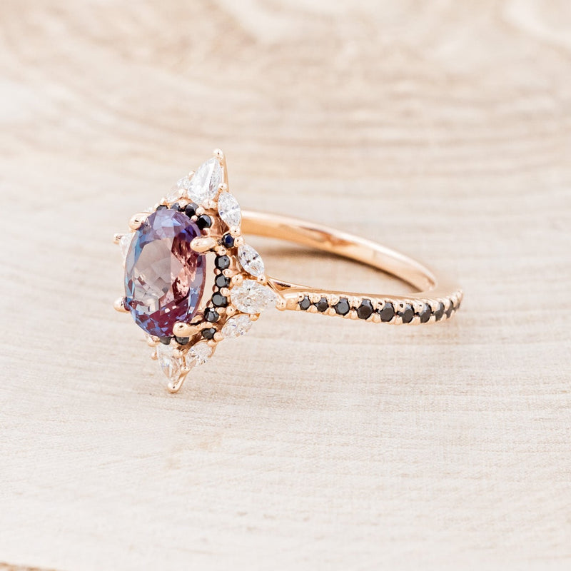 Shown here is "North Star", an oval lab-created alexandrite women's engagement ring with a diamond halo and black diamond accents, facing left. Many other center stone options are available upon request.