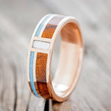 Shown here is "Bower", a custom, handcrafted men's wedding ring featuring a vertical channel with mother of pearl and 2 horizontal channels with turquoise and ironwood inlays, upright facing left. Additional inlay options are available upon request.