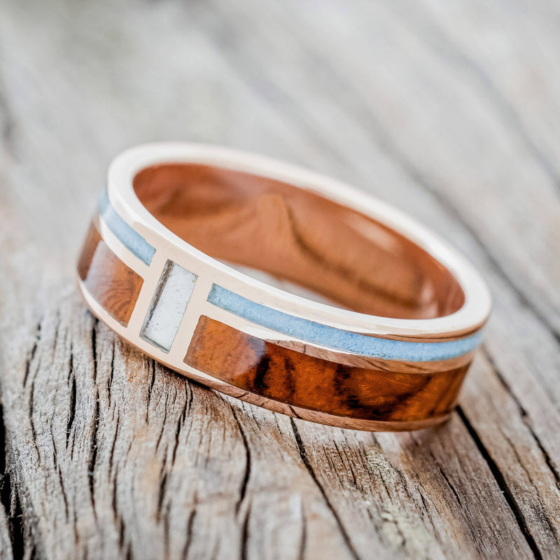 Shown here is "Bower", a custom, handcrafted men's wedding ring featuring a vertical channel with mother of pearl and 2 horizontal channels with turquoise and ironwood inlays, tilted left. Additional inlay options are available upon request.