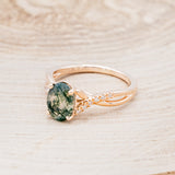 Shown here is "Roslyn", an oval moss agate women's engagement ring with diamond accents, facing left. Many other center stone options are available upon request.
