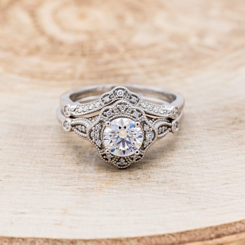 Shown here is "Eileen", a vintage-style moissanite women's engagement ring with a diamond halo, accents, and tracer, front facing. Many other center stone options are available upon request.