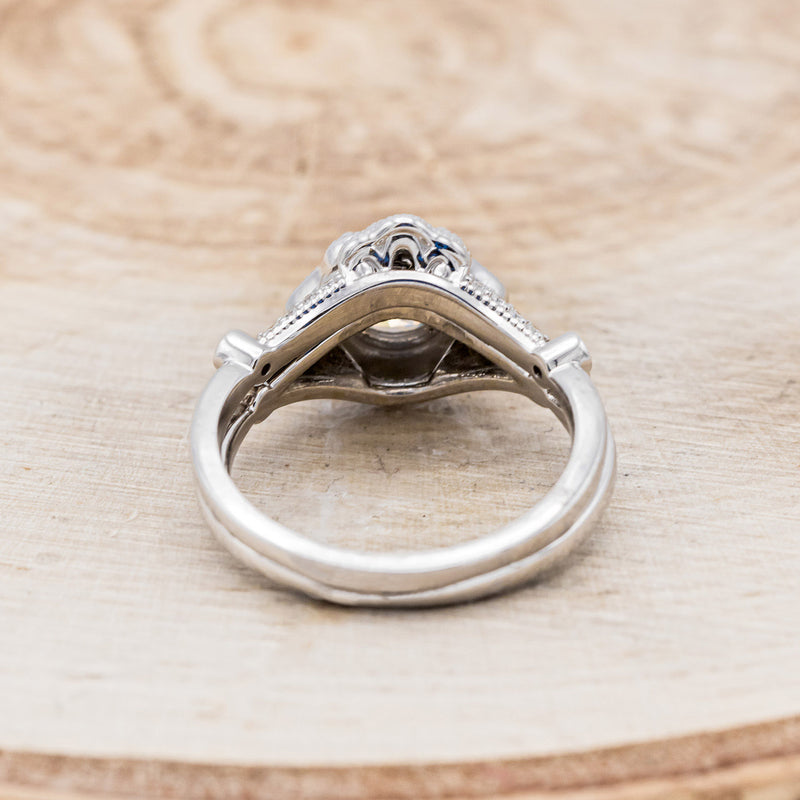 Shown here is "Eileen", a vintage-style moissanite women's engagement ring with a diamond halo, accents, and tracer, back view. Many other center stone options are available upon request.