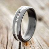 Shown here is "Nirvana", a custom, handcrafted wedding ring featuring an antler inlay & beveled edges, shown here on a fire-treated black zirconium band, upright facing left. Additional inlay options are available upon request.