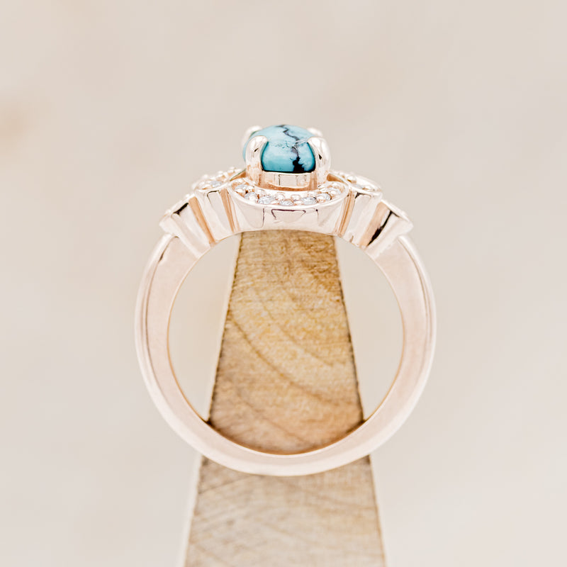 Shown here is "Nora", a vintage-style turquoise women's engagement ring with diamond accents, side view on stand. Many other center stone options are available upon request.