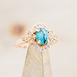 Shown here is "Nora", a vintage-style turquoise women's engagement ring with diamond accents, on stand facing slightly right. Many other center stone options are available upon request. 