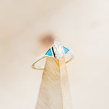 Shown here is "Nile", an art deco-style moissanite women's engagement ring with turquoise inlays and tracer, on stand facing slightly right. Many other center stone options are available upon request.  