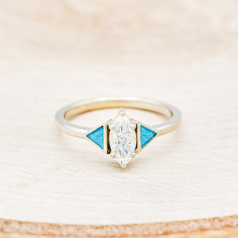Shown here is "Nile", an art deco-style moissanite women's engagement ring with turquoise inlays and tracer, front facing. Many other center stone options are available upon request.